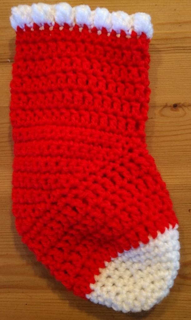 a crocheted advent stocking in red and white